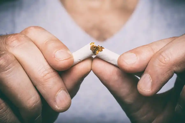 Hilfe bei Nikotinsucht und Entwöhnung: Mann zerbricht Zigarrette
