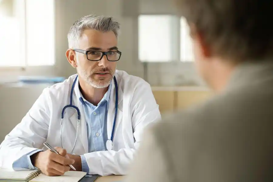 Arzt bei Reha im Beratungsgespräch mit Patienten Arzt bei Reha im Beratungsgespräch mit Patienten