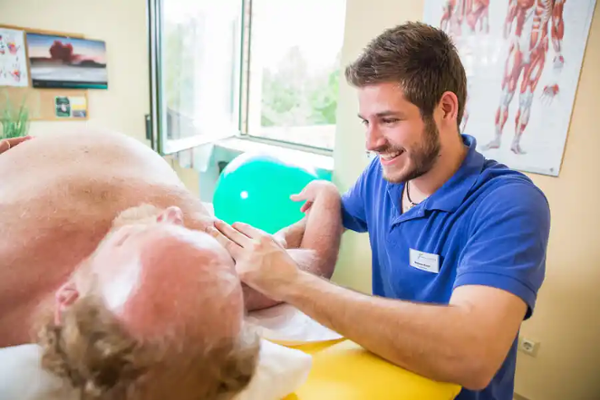 Reha-Behandlung: Therapeut behandelt Patient Reha-Behandlung: Therapeut behandelt Patient