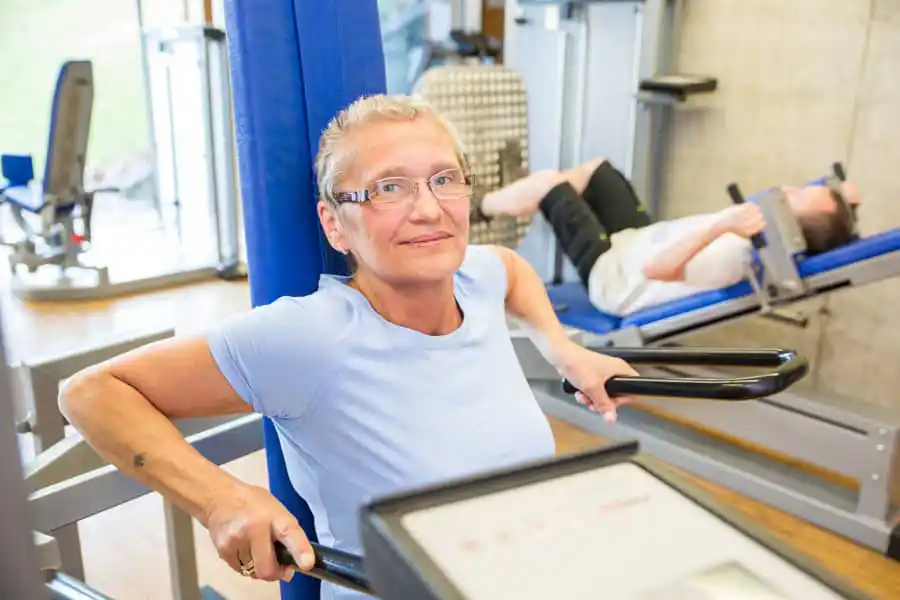 Reha-Behandlung: Patientin macht Übungen an einem Gerät